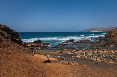 La Pared volkanik plajı veya Playa de La Pared Fuerteventura güney batı kıyısı, Kanarya Adaları, İspanya, aşınmış manzara ve siyah kumla. Ekim 2019