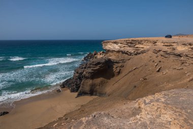 La Pared volkanik plajı veya Playa de La Pared Fuerteventura güney batı kıyısı, Kanarya Adaları, İspanya, aşınmış manzara ve siyah kumla. Ekim 2019