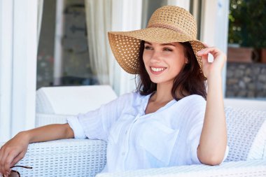 Terasta hasır sandalye üzerinde güzel kadın rahatlatır