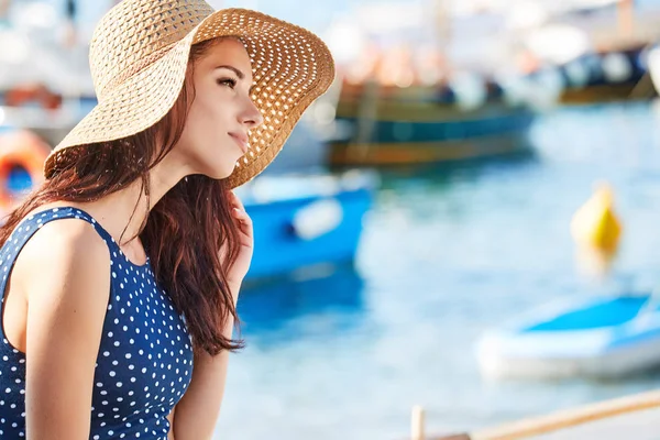 Vacker kvinna i stråhatt som sitter på båten på stranden. Shopaholic — Stockfoto
