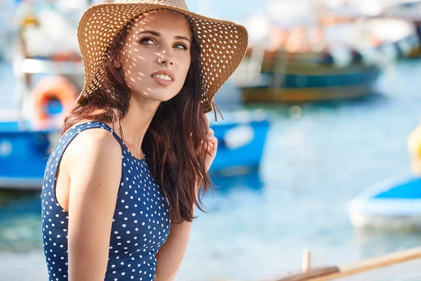 Vacker kvinna i stråhatt som sitter på båten på stranden. Shopaholic — Stockfoto