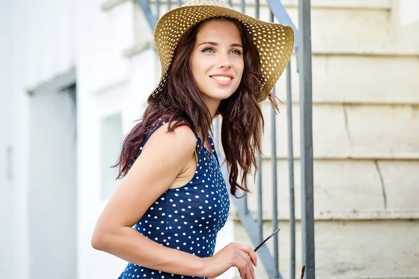 Güzel genç kadın elbise ve hasır şapka t yürüyor