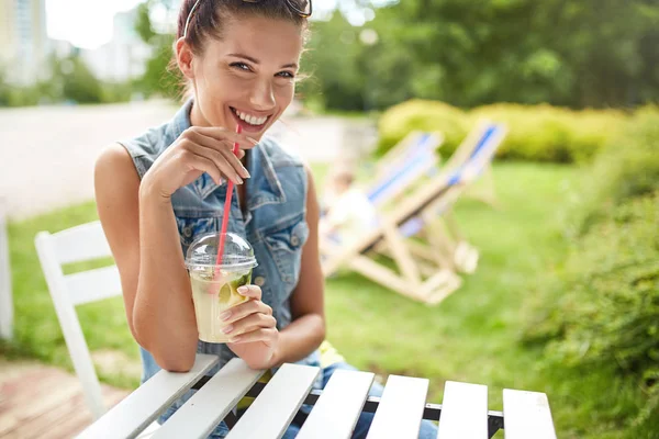 Härlig ung leende kvinna som dricker lemonad. Sommarkoncept — Stockfoto