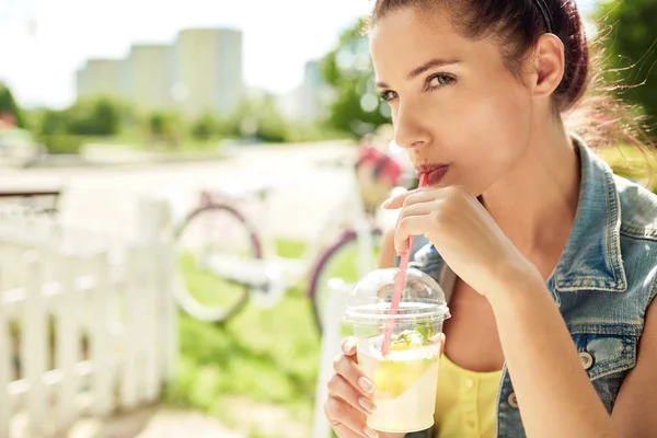 Adorável jovem sorrindo mulher bebendo limonada. Conceito de verão — Fotografia de Stock