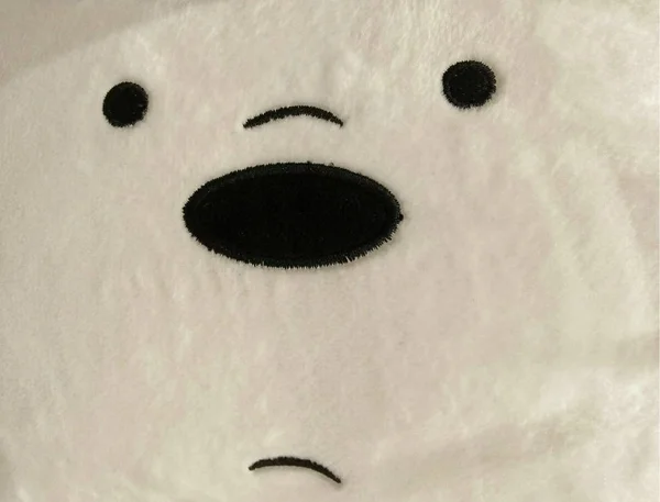 Close up view: Abstract puzzled face of a cute bear doll toy.