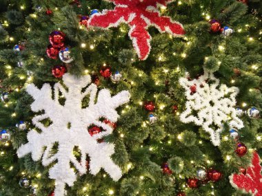 Beyaz kar taneleri, kırmızı yıldızlar ve süs topları olan yeşil çam dallarının arka planı. Yeni Yıl ve Mutlu Noeller Kavramı..