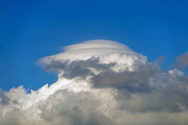 Yazın gökyüzünde, Cumulus bulutlarının tepesindeki eşsiz bulut benzeri daire.