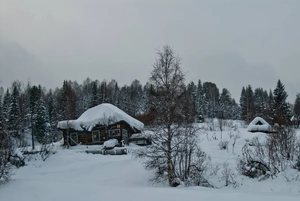 Wooden house in the winter with the smoke from the chimney — Stock Photo, Image