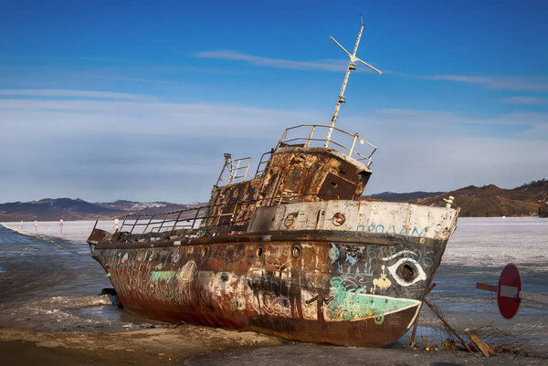 Ржавая старая лодка на скалах
