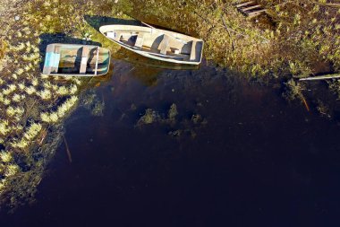 Nehrin çimenli kıyısında kayıklar