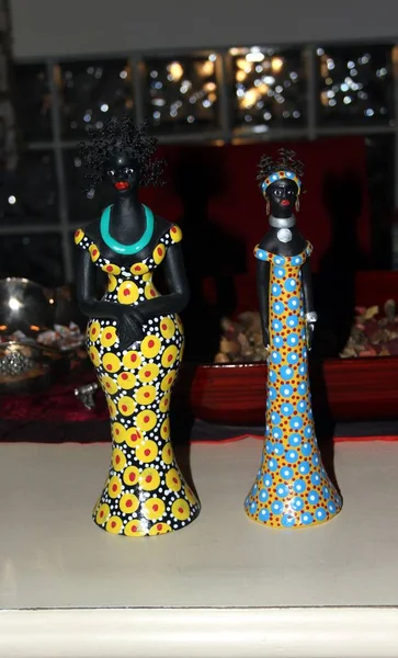 Zwei kleine Statuen afrikanischer Frauen mit farbenfrohen Kleidern — Stockfoto