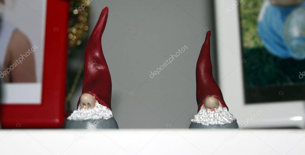 two small statues of two elves dressed in red