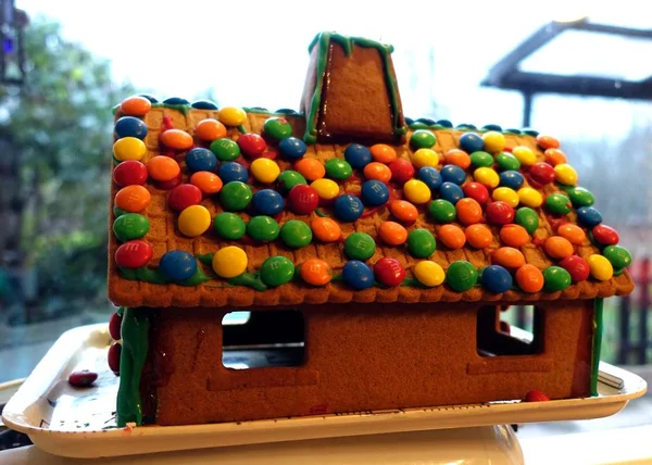 Une maison en pain d'épice fait maison avec le toit couvert de chocolats — Photo