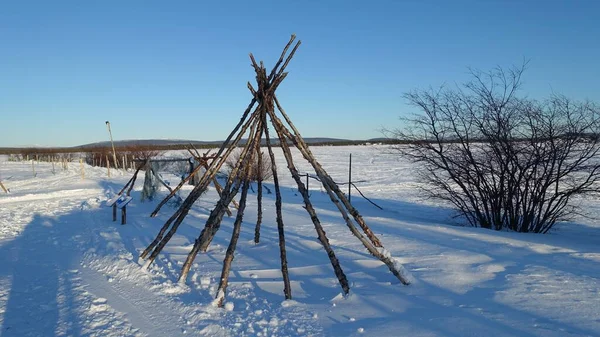 the remains of a Sami camp on the banks of the frozen lake in northern Sweden