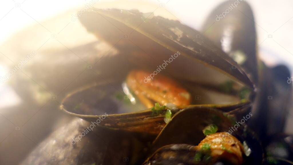 Plate of mussels with toasted bread, salt, pepper and parsley