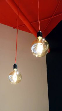 Bir dairenin tavanından sarkan iki küresel lamba.