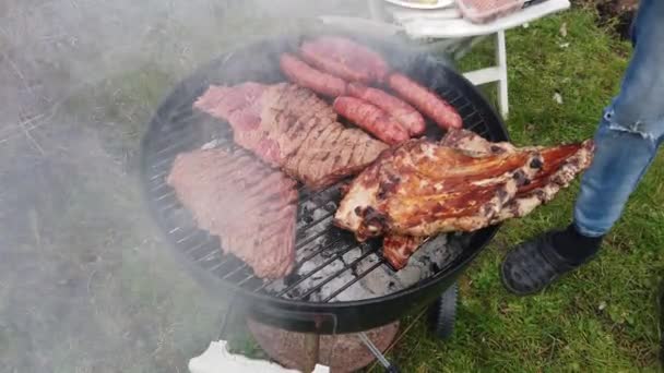 I denne karanteneperioden er grillen med blandet kjøtt i hagen ideell. . – stockvideo