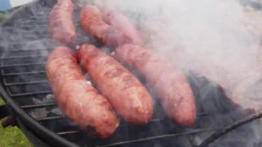 Bu karantina döneminde, bahçede ızgara et dinlendiricidir. Domuz sosisleri terler ve közlerle temas edince çok fazla duman çıkarırlar.