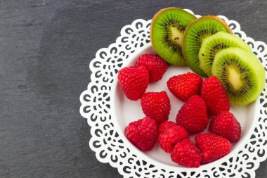 Beyaz bir sanatsal plaka üzerinde taze kırmızı ahududu 