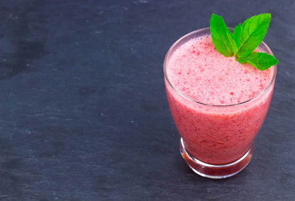 Uma xícara de suco de morango com folhas de hortelã em um fundo colorido oriental — Fotografia de Stock