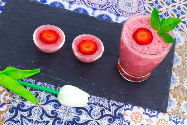 Šálek šťávy jahody s mátou listy na orientální barevné pozadí — Stock fotografie