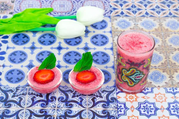 Una taza de jugo de fresa con hojas de menta sobre un fondo colorido oriental —  Fotos de Stock