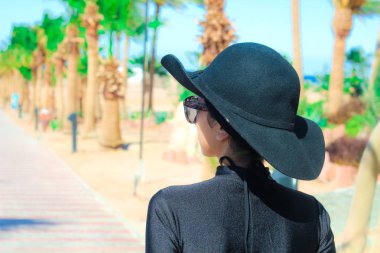 Gülme ve sahip eğlenceli güneş altında siyah şapkalı Bayan