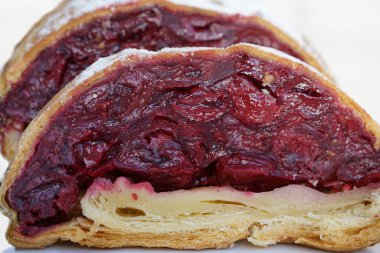 Kirazlı çöreğin iştah açıcı dilimleri lezzetli bir tatlıdır, yakın plan ve beyaz arka plan