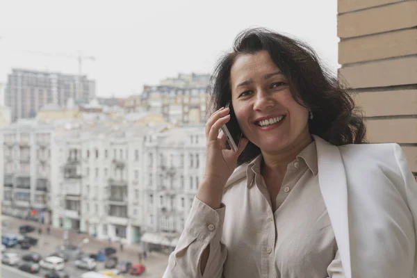 Mutlu esmer girişimci, balkonda telefonla konuşuyordu. Esnek saatler ve uzaktan çalışma konsepti