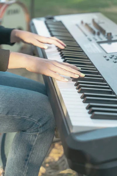 Girl plays piano keyboard, hand close up