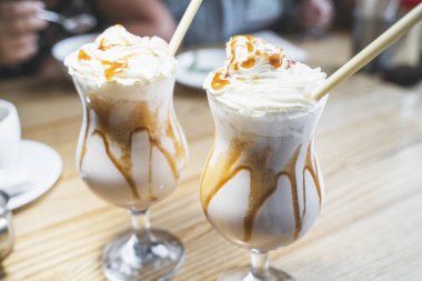 Krem şantili milkshake ve kafede çevre dostu bambu pipetli bardaklarda karamel. Plastiksiz konsept