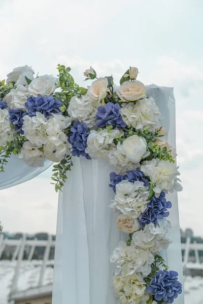 Wedding arch for the ceremony on the roof of the building, fragment, close up. Symbol of eternal love between man and woman. Background is city view, vertical image