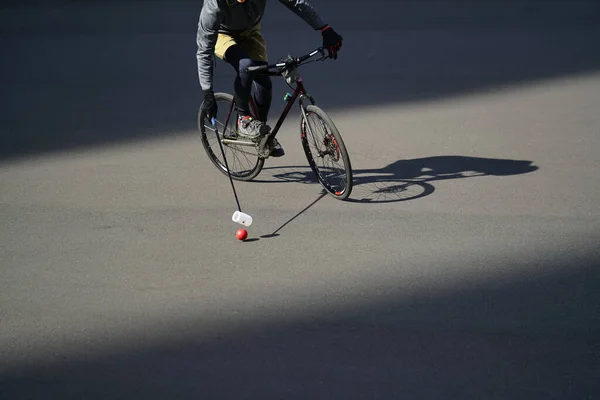 Uomo che gioca a polo urbano. Ciclista sta colpendo la palla con un bundy, primo piano — Foto Stock