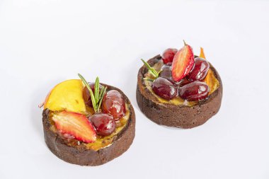 Beyaz arka planda meyveli ve meyveli iki lezzetli pasta, izole edilmiş ve kapatılmış.