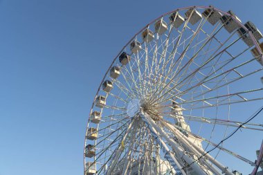 Ukrayna, Kiev 'de güneşli bir günde büyük dönme dolap dönüyor. İnsanlar gözlem altında ve eğleniyorlar. Düşük açı görünümü, alanı kopyala ve kapat.
