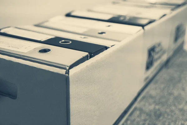 Belgeler arşivde korunuyor. Ofis belgeleri klasörlerde dosyalandı ve kutu kapları arşivlenmeye hazır. Siyah ve beyaz resim, sepia tonlu ve makro