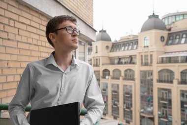 Gri kedi, merkez ofisin yanındaki pencere eşiğinde bilişim teknolojisi ekipmanıyla uyuyor. Evden çalışma ve uzaktan erişim kavramı.