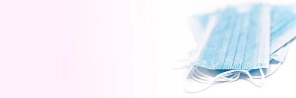 Korona COVID-19 enfeksiyonunu önlemek için antivirüs koruma maskesi. Pembe arka planda mavi tıbbi yüz maskesi, anti virüs koruma konsepti, kopyalama alanı olan pankart.