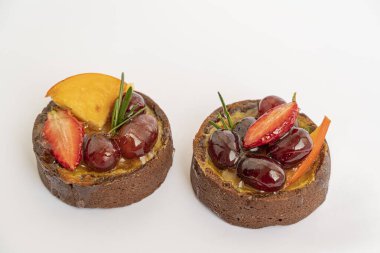 Beyaz arka planda meyveli ve meyveli iki lezzetli pasta, izole edilmiş ve makro.