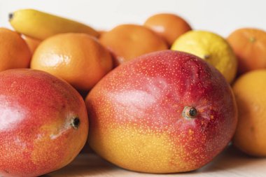 Mango ve narenciyenin durgun yaşamı beyaz arka planda, izole edilmiş. Meyveler lezzetli görünüyor ve dopamin ve vitamin dolu. Doğal ürünler ve sağlıklı gıda konsepti, makro.