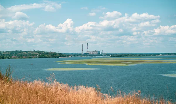 Güneşli bir günde arka planda termal elektrik santrali olan Dniper nehri tarafı, Ukrayna.