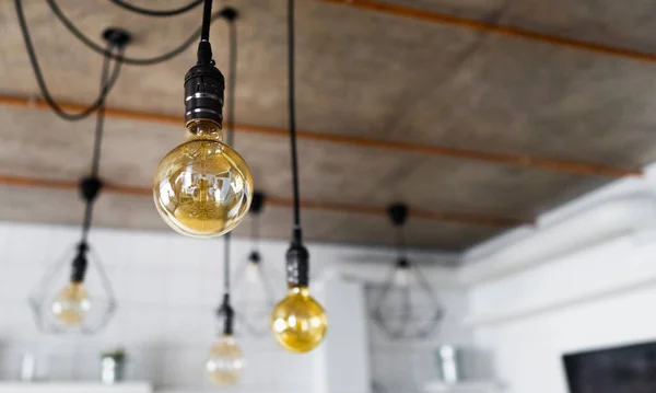 Modern mutfakta asılı büyük, eski, parlak ampuller. Düz telli dekoratif antika Edison ampulleri. Yetersiz filamantasyon ampulleri elektriği boşa harcıyor. Küçültülebilir, ılık beyaz, E27