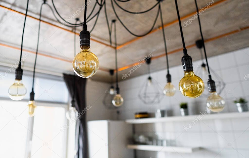 Decorative antique edison light bulbs with straight wire. Big vintage incandescent light bulbs hanging in modern kitchen. Inefficient filament light bulbs waste electricity. Dimmable, warm white, E27