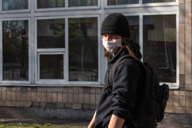 Lutsk, Ukrayna - 20 Nisan 2020: Coronavirus salgınının ortasında halk sokaklarında maske takan bir adam. Şehirdeki bulaşıcı hastalıklar sırasında sağlık koruma ve virüs salgınını önleme