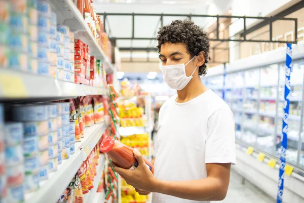22-year-old man with protective mask makes purchase in supermarket