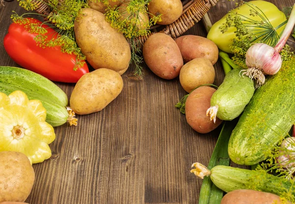 Verduras rojas, amarillas y verdes se encuentran junto a una canasta de mimbre — Foto de Stock