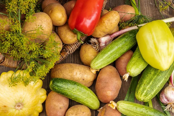 Verduras rojas, amarillas y verdes se encuentran junto a una canasta de mimbre — Foto de Stock