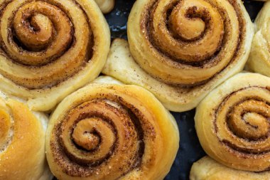 Tarçınlı hamur hamurundan kıvrılmış çörekler, kamış şekeri.