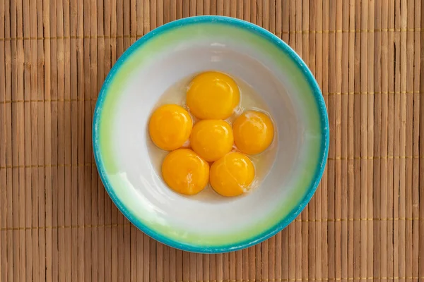 Tavuk sarısı yeşil kenarlı beyaz bir tabakta yatar.