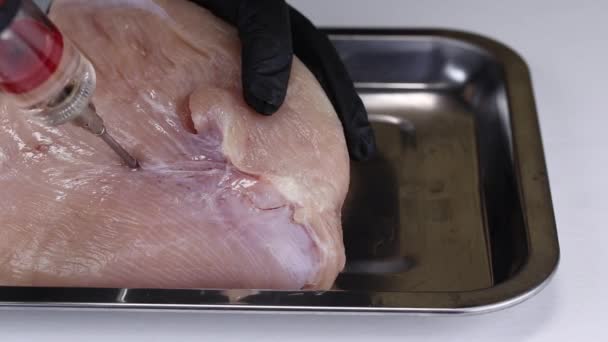 一名厨师用注射器将亚硝酸盐盐的溶液泵入火鸡肉浆中 并将其放在金属盘子中 并将其关闭 — 图库视频影像